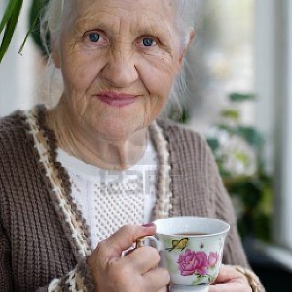 10360060 personnes agees femme souriante avec tasse de the sur le balcon
