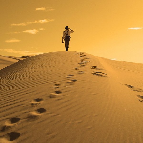 Golden desert sand dune man back footprints walking sky 1024x768
