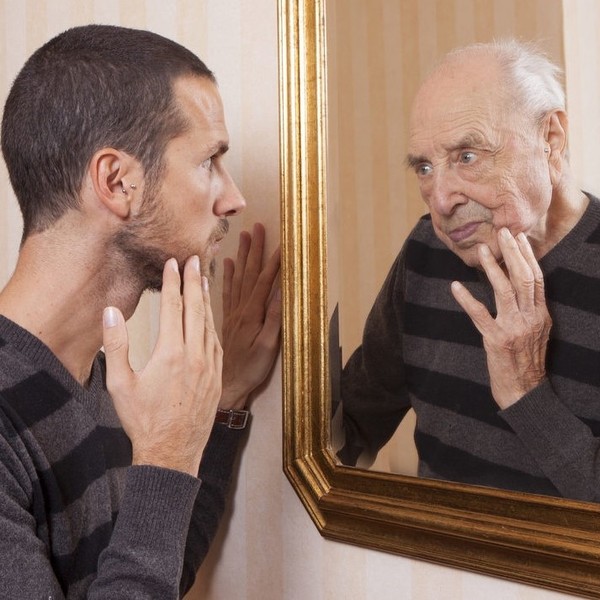Young man looking at an older himself in the mirror 1506432576
